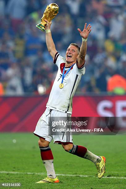 Bastian Schweinsteiger of Germany holds up the World Cup trophy after the 2014 FIFA World Cup Brazil Final match between Germany and Argentina at...
