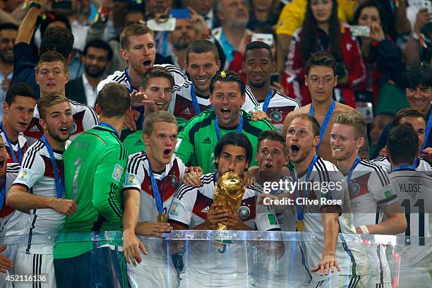 Sami Khedira of Germany kisses the World Cup trophy with teammates after defeating Argentina 1-0 in extra time during the 2014 FIFA World Cup Brazil...