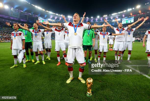 Bastian Schweinsteiger of Germany leads team-mates in celebration after the 2014 FIFA World Cup Brazil Final match between Germany and Argentina at...