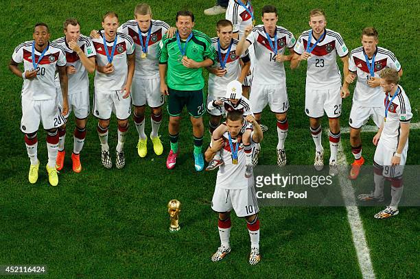 Lukas Podolski of Germany celebrates with his son Louis Podolski and teammates after defeating Argentina 1-0 in extra time during the 2014 FIFA World...