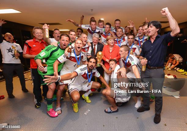 Head Coach Joachim Loew of Germany celebrates with players and Angela Merkel,Chancellor of Germany in the Germany dressing room after the 2014 FIFA...