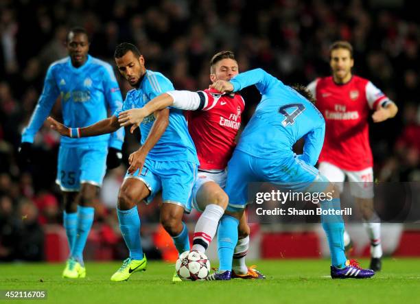 Olivier Giroud of Arsenal is closed down by Alaixys Romao and Lucas Mendes of Marseille during the UEFA Champions League Group F match between...