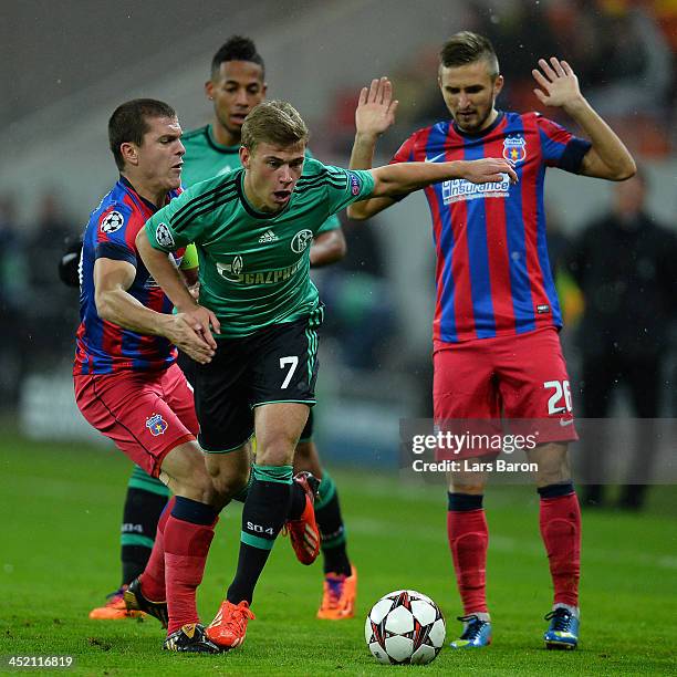 Max Meyer of Schalke is challenged by Alexandru Bourceanu and Ionut Neagu of Steaua during the UEFA Champions League Group E match between FC Steaua...