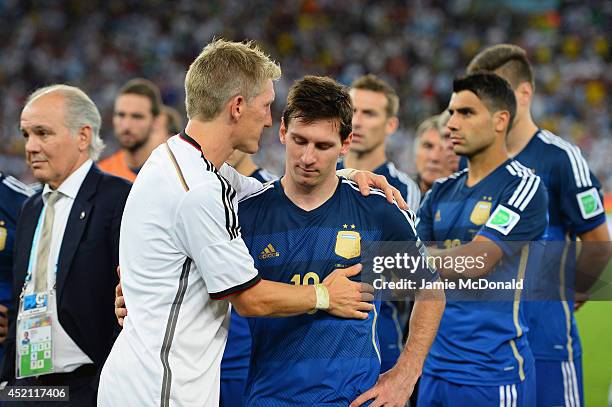 Bastian Schweinsteiger of Germany consoles Lionel Messi of Argentina after Germany's 1-0 victory in extra time during the 2014 FIFA World Cup Brazil...