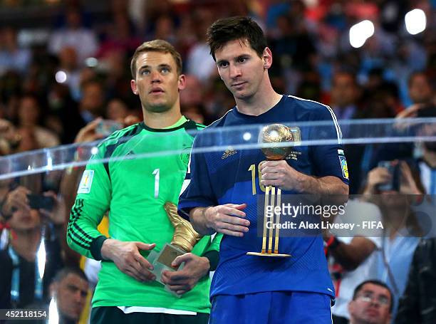 Manuel Neuer of Germany receives the Golden Glove trophy and Lionel Messi of Argentina receives the Golden Ball during the award ceremony after the...