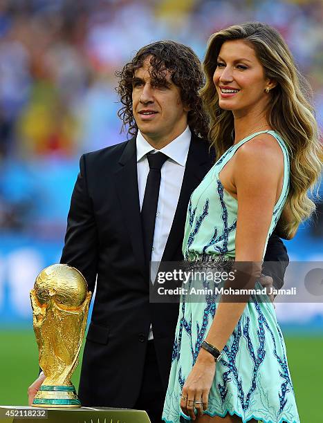 Former Spanish international Carles Puyol and model Gisele Bundchen present the World Cup trophy in a Louis Vuitton case prior to the 2014 FIFA World...