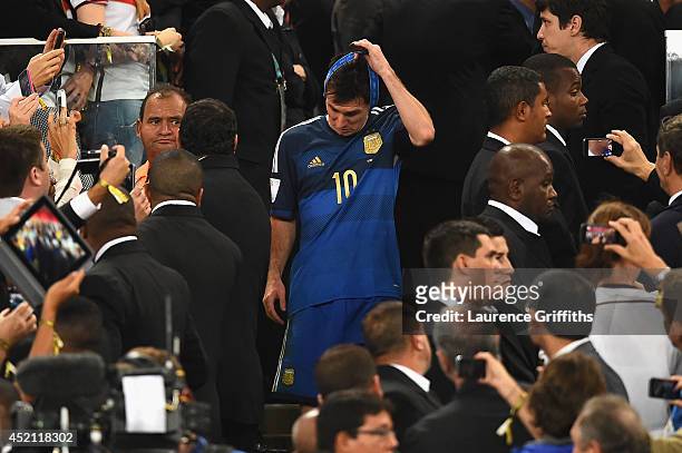 Lionel Messi of Argentina takes his medal off after being defeated by Germany 1-0 during the 2014 FIFA World Cup Brazil Final match between Germany...