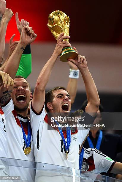 Philipp Lahm of Germany lifts the World Cup trophy to celebrate with his teammates during the award ceremony after the 2014 FIFA World Cup Brazil...