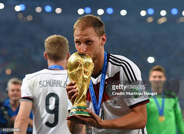 Benedikt Hoewedes of Germany kisses the World Cup trophy after defeating Argentina 1-0 in extra time during the 2014 FIFA World Cup Brazil Final...