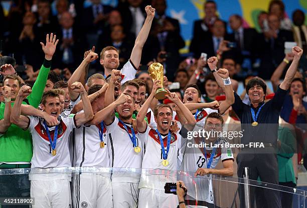 Philipp Lahm of Germany lifts the World Cup trophy to celebrate with his teammates during the award ceremony after the 2014 FIFA World Cup Brazil...