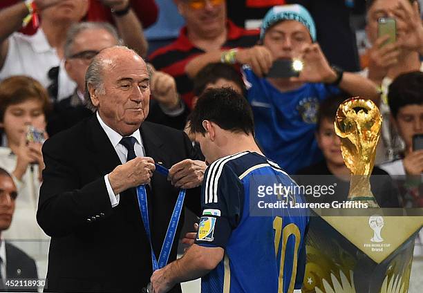 Lionel Messi of Argentina receives the second place medal from FIFA President Joseph S. Blatter during the award ceremony after the 2014 FIFA World...