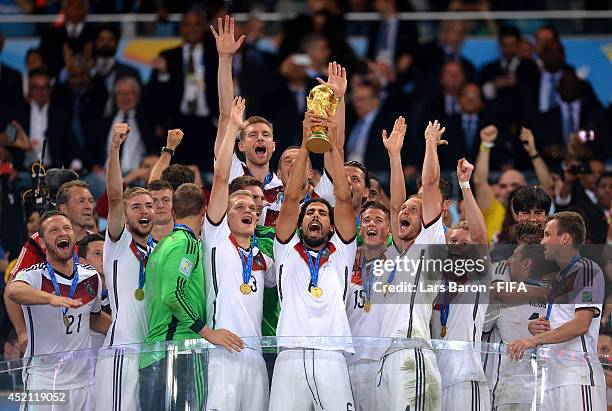 Sami Khedira of Germany lifts the World Cup trophy to celebrate with his teammates during the award ceremony after the 2014 FIFA World Cup Brazil...