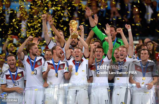 Bastian Schweinsteiger of Germany lifts the World Cup trophy to celebrate with his teammates during the award ceremony after the 2014 FIFA World Cup...