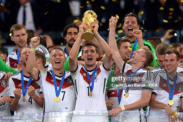 Miroslav Klose of Germany lifts the World Cup trophy to celebrate with his teammates during the award ceremony after the 2014 FIFA World Cup Brazil...