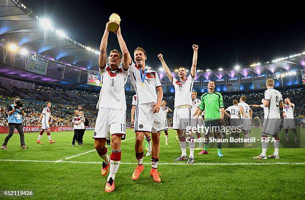 Miroslav Klose of Germany and Erik Durm of Germany lift the World Cup trophy to celebrate after the 2014 FIFA World Cup Brazil Final match between...