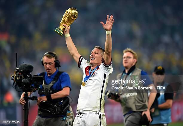 Bastian Schweinsteiger of Germany holds up the World Cup trophy after the 2014 FIFA World Cup Brazil Final match between Germany and Argentina at...