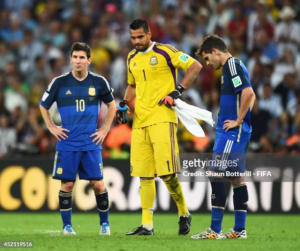 Lionel Messi, Sergio Romero and Fernando Gago of Argentina show their dejection after the 2014 FIFA World Cup Brazil Final match between Germany and...
