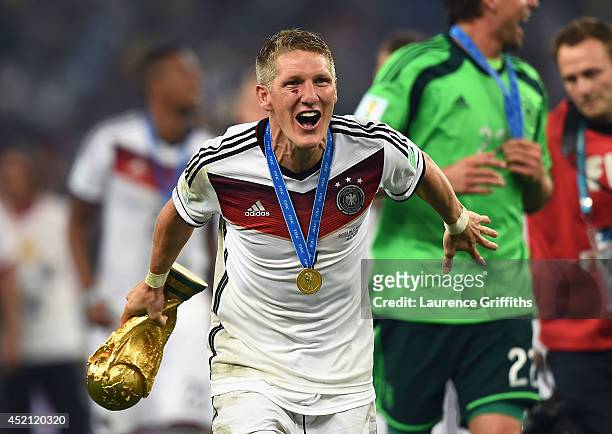 Bastian Schweinsteiger of Germany celebrates with the World Cup trophy after defeating Argentina 1-0 in extra time during the 2014 FIFA World Cup...