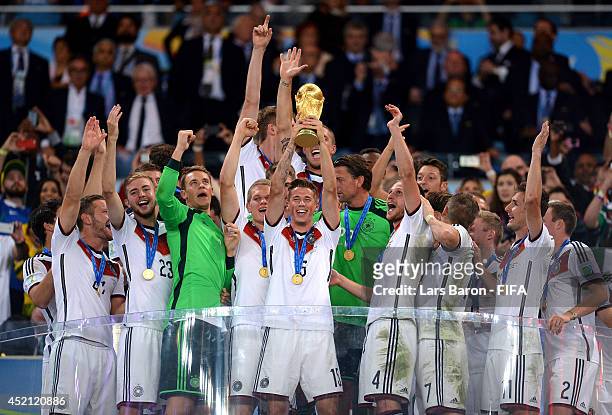 Erik Durm of Germany lifts the World Cup trophy to celebrate with his teammates during the award ceremony after the 2014 FIFA World Cup Brazil Final...
