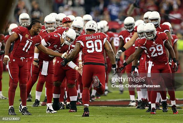 Wide receiver Larry Fitzgerald, quarterback Carson Palmer and running back Alfonso Smith of the Arizona Cardinals high-five defensive end Darnell...