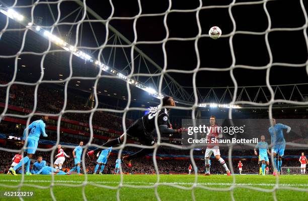 Steve Mandanda of Marseille fails to stop Jack Wilshere of Arsenal score the opening goal during the UEFA Champions League Group F match between...