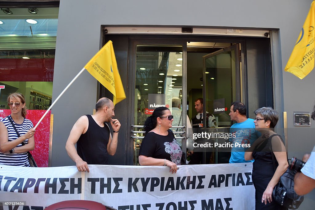 Demonstrators stand infront of Plaisio shop in Athens...