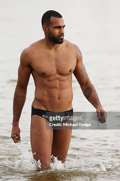 Heritier Lumumba of the Magpies walks out of the water during a Collingwood Magpies AFL recovery session at St Kilda Beach on July 14, 2014 in...