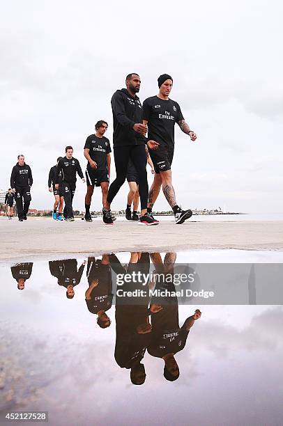 Heritier Lumumba and Jesse White walk on the foreshore during a Collingwood Magpies AFL recovery session at St Kilda Beach on July 14, 2014 in...