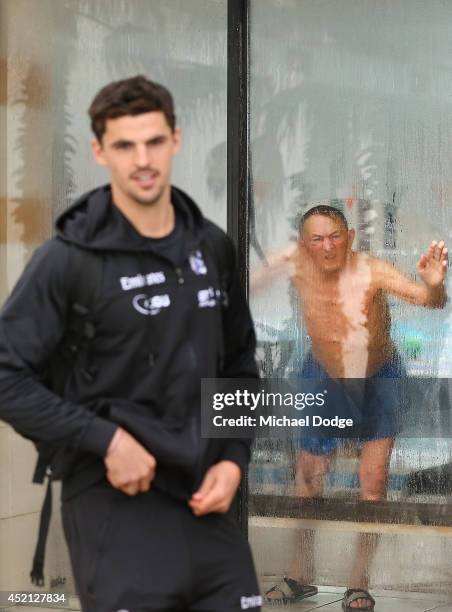 Scott Pendlebury of the Magpies arrives as an onlooker peers through the St.Kilda Baths window during a Collingwood Magpies AFL recovery session at...