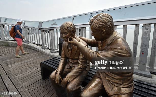 Statue of a man comforting a person is placed to dissuade suicides on Mapo Bridge, a common site for suicides, over the Han river in Seoul on July...