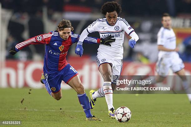 Basel's defender Kay Voser vies with Chelsea's Brazilian midfielder Willian during an UEFA Champions League group E football match FC Basel against...