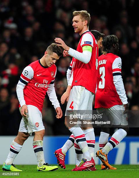 Per Mertesacker of Arsenal congratulates Jack Wilshere of Arsenal on scoring his second goal during the UEFA Champions League Group F match between...