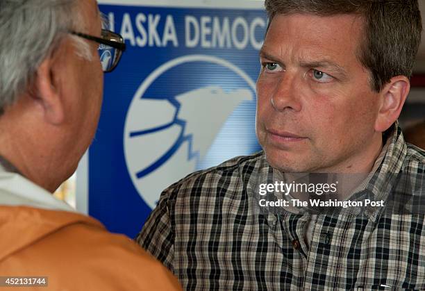 Senator Mark Begich listens to the concerns of a Barrow resident during the opening of his campaign headquarters in Barrow, Alaska on July 6, 2014.