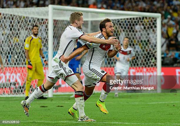 Mario Goetze of Germany celebrates scoring his team's first goal with Andre Schuerrle during the 2014 FIFA World Cup Brazil Final match between...