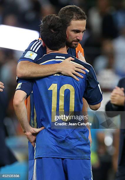 Lionel Messi and Gonzalo Higuain of Argentina hug each other after losing the 2014 FIFA World Cup Brazil Final match between Germany and Argentina at...