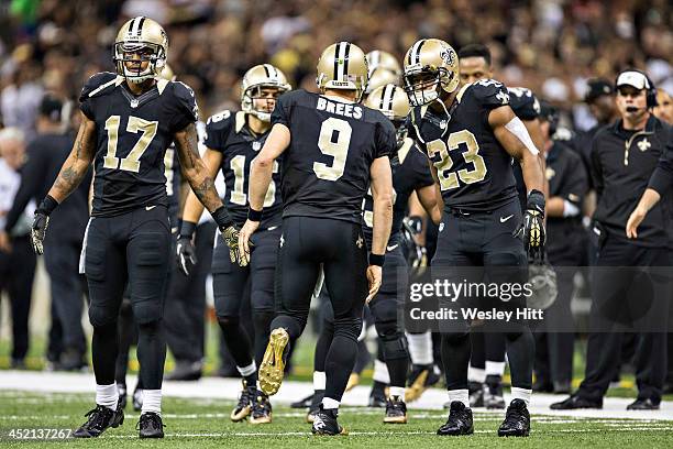 Drew Brees is congratulated by Robert Meachem and Pierre Thomas of the New Orleans Saints after a touchdown against the San Francisco 49ers at...