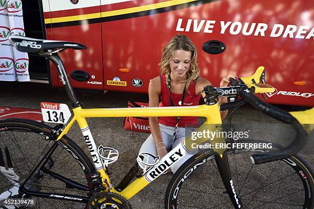 French cyclist Marion Rousse and girlfriend of France's Tony Gallopin, wearing the overall leader's yellow jersey, looks at the yellow bike of Tony...