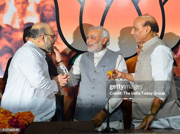 Indian Prime Minister Narendra Modi offering sweet to Amit Shah, the newly appointed president of India's ruling Bharatiya Janata Party as outgoing...