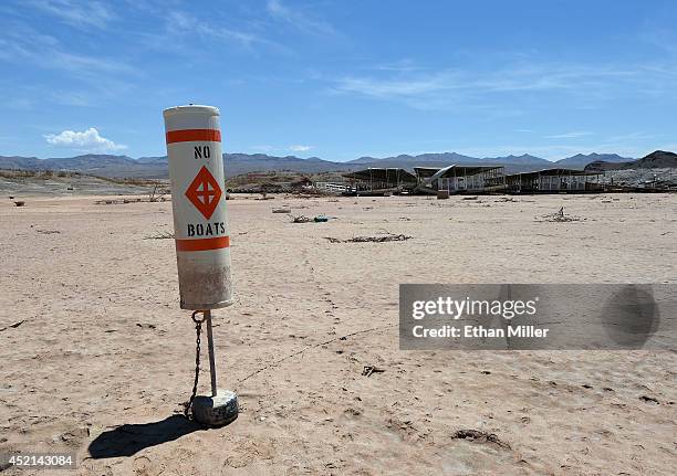 Buoy warning "no boats" stands on dirt at the abandoned Echo Bay Marina on July 13, 2014 in the Lake Mead National Recreation Area, Nevada. The...