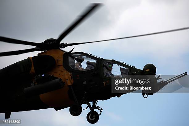 Pilots fly a T129 ATAK combat helicopter, produced for the Turkish Army by Turkish Aerospace Industries Inc. , during an aerial flying display on the...