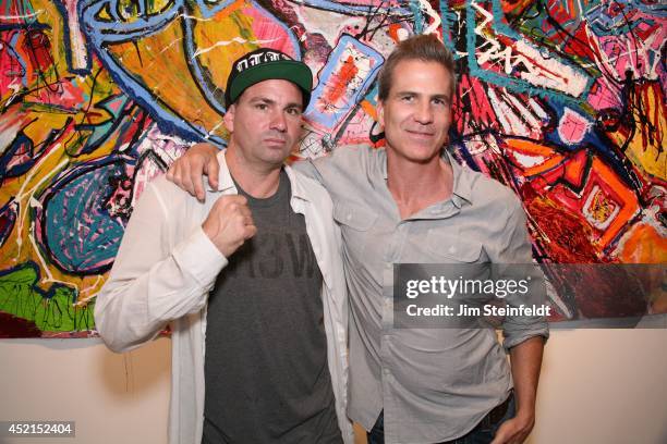 Artist Danny Minnick at his art exhibit poses with David Gardner at Gallerie Sparta in Los Angeles, California on July 10, 2014.