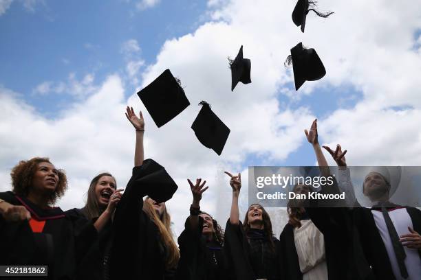 Students throw their caps in the air ahead of their graduation ceremony at the Royal Festival Hall on July 15, 2014 in London, England. Students of...