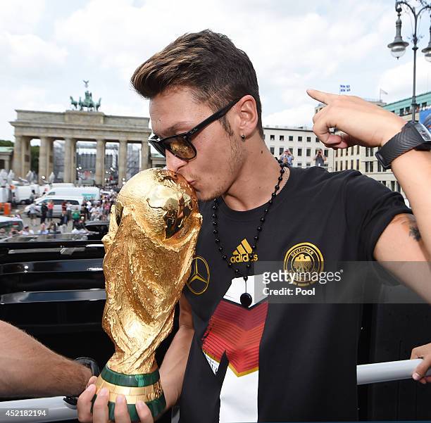 Mesut Oezil celebrates on the open top bus at the German team victory ceremony on July 15, 2014 in Berlin, Germany. Germany won the 2014 FIFA World...
