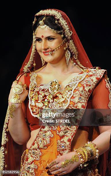 Indian Bollywood film actress Zarine Khan presents a creation during the India International Jewellery Week 2014 in Mumbai on July 15, 2014. AFP...