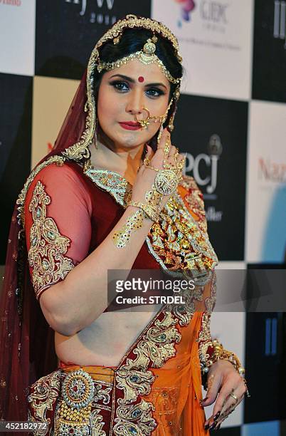 Indian Bollywood film actress Zarine Khan presents a creation during the India International Jewellery Week 2014 in Mumbai on July 15, 2014. AFP...