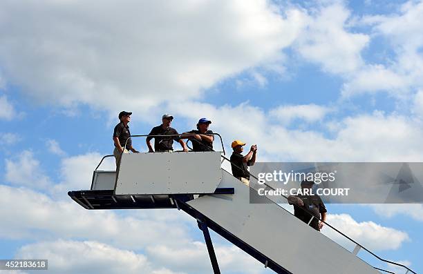 Boeing employees watch an air display from an aircraft access platform on the second day of the Farnborough International Air show in Hampshire,...