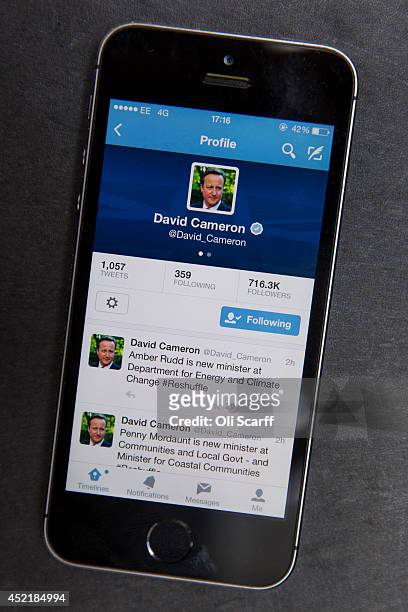 In this photo illustration, a mobile phone displays the Twitter feed of British Prime Minister David Cameron as he conducts a reshuffle of his...