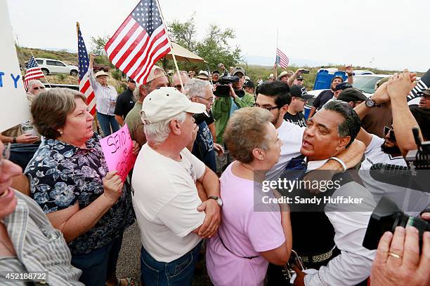 Pro and anti-immigration activists face-off during a protest along Mt. Lemmon Road in anticipation of buses carrying illegal immigrants on Jully 15,...