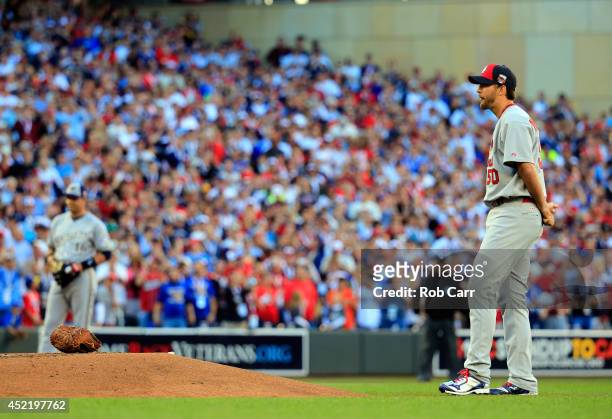 National League All-Star Adam Wainwright of the St. Louis Cardinals places his glove on the mound and waits as Derek Jeter of the New York Yankees...