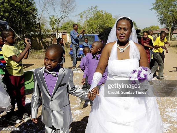 Anele Masilela, a nine year-old watches as his wife Helen Shabangu, 62 year-old kisses her 'real life' husband Abel, at their white wedding on July...